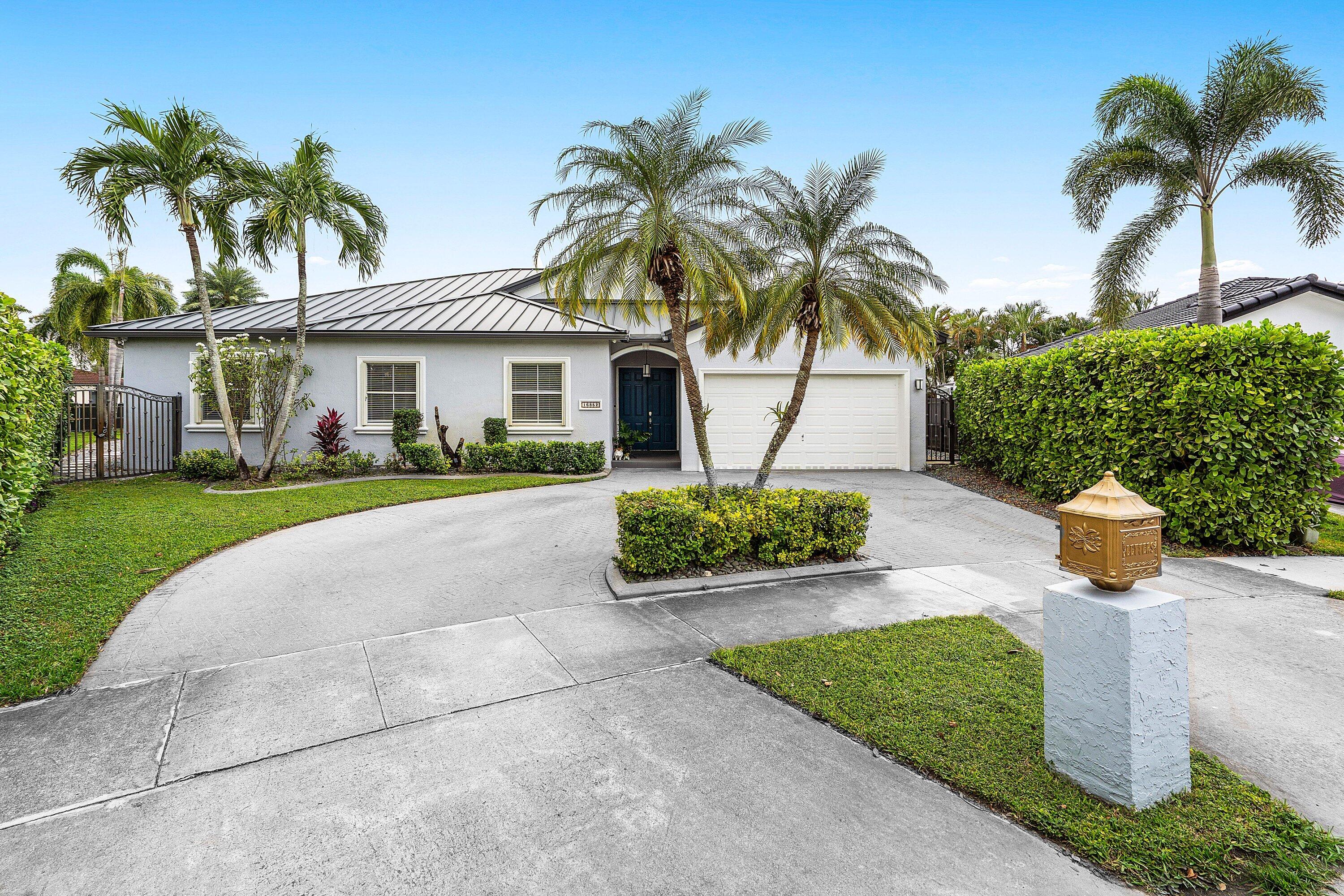 16852 Northwest 88th Path Miami Lakes, FL 33018 - Photo 3 of 34 a front view of a house with garden