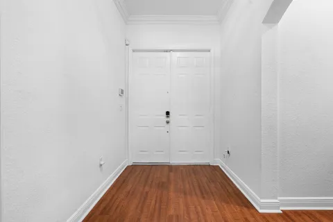a view of a room with wooden floor and white walls
