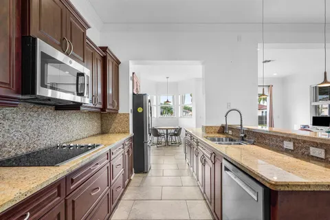 a kitchen with stainless steel appliances granite countertop a sink a stove and a microwave