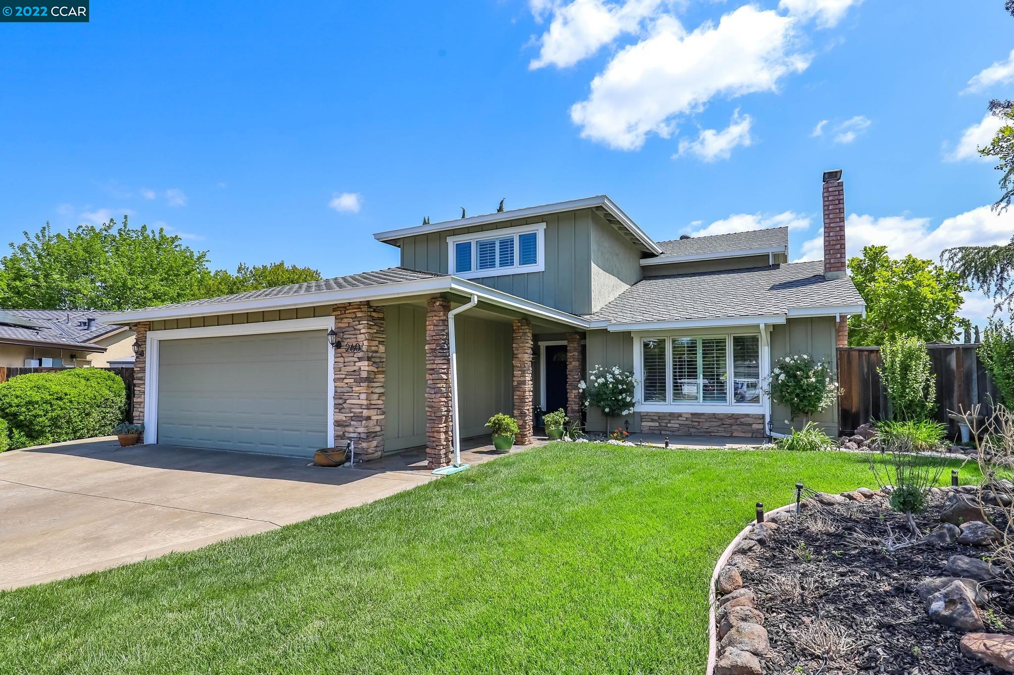 a front view of a house with a garden and yard