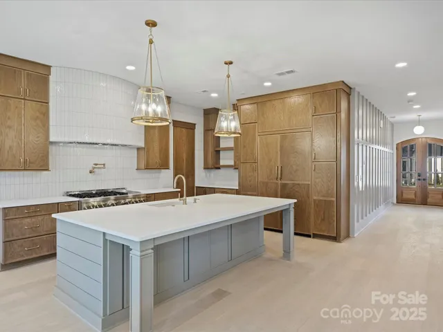 a kitchen with kitchen island a sink stove and refrigerator