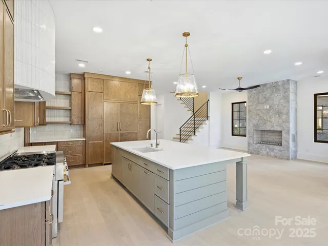 a large white kitchen with a sink a stove and a refrigerator