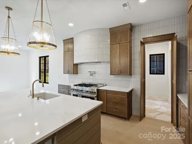 a kitchen that has a lot of cabinets in it and wooden floors