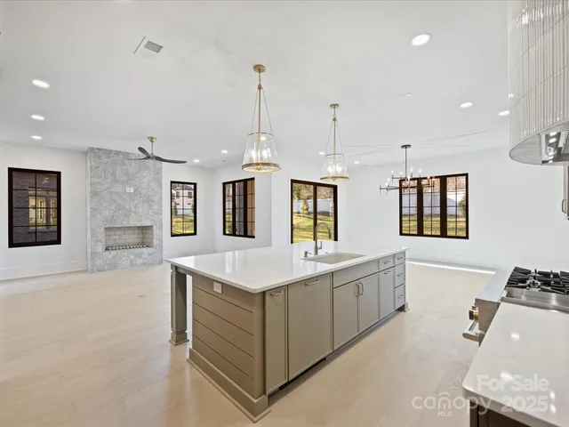 a large white kitchen with cabinets and a wooden floor