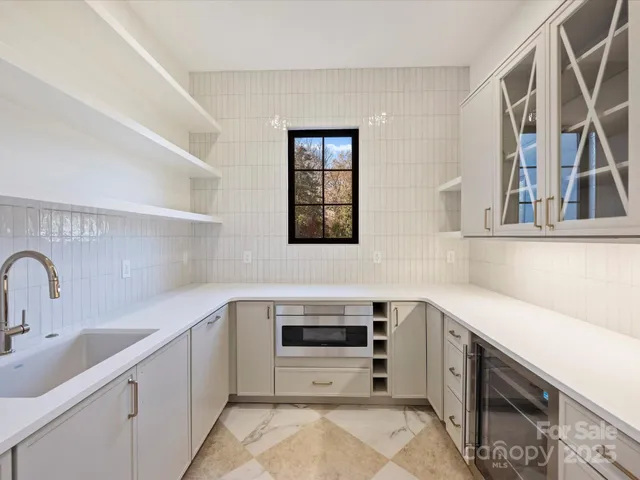 a kitchen with stainless steel appliances a sink dishwasher and cabinets with wooden floor