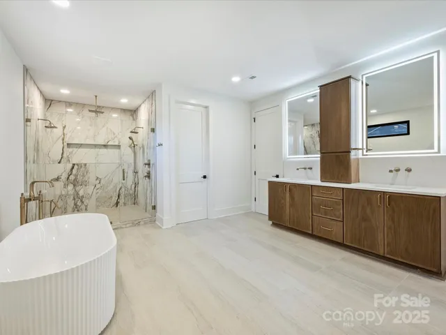 a bathroom with a tub a sink and a shower