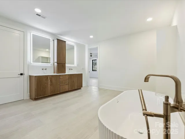 a bathroom with a tub a sink and mirror