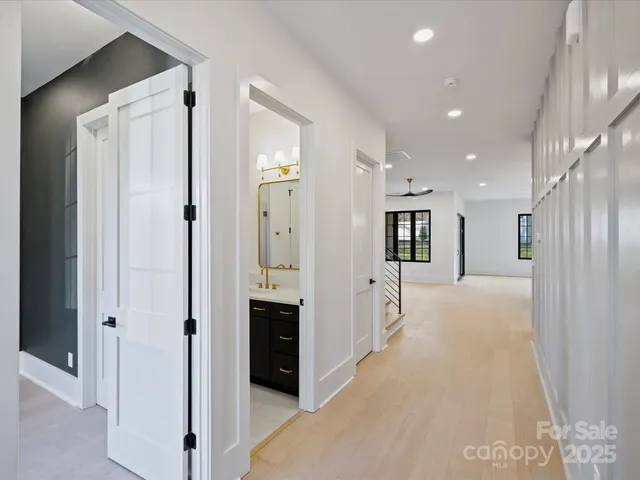 a view of a hallway with large mirror and wooden floor