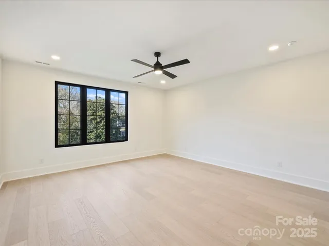 an empty room with a ceiling fan and window