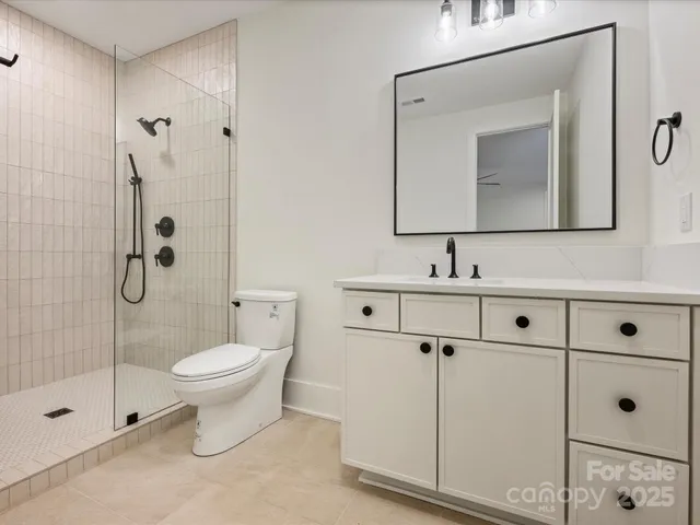 a bathroom with a toilet sink a mirror and shower