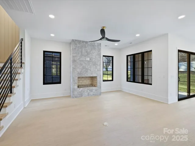 a view of an empty room with a fireplace and a window
