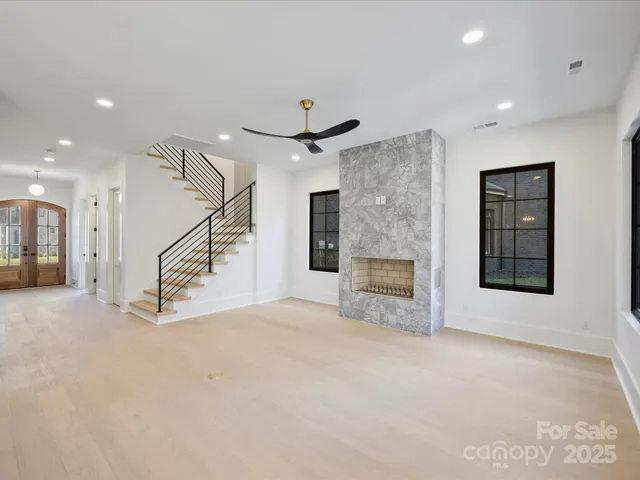 an empty room with windows and a ceiling fan