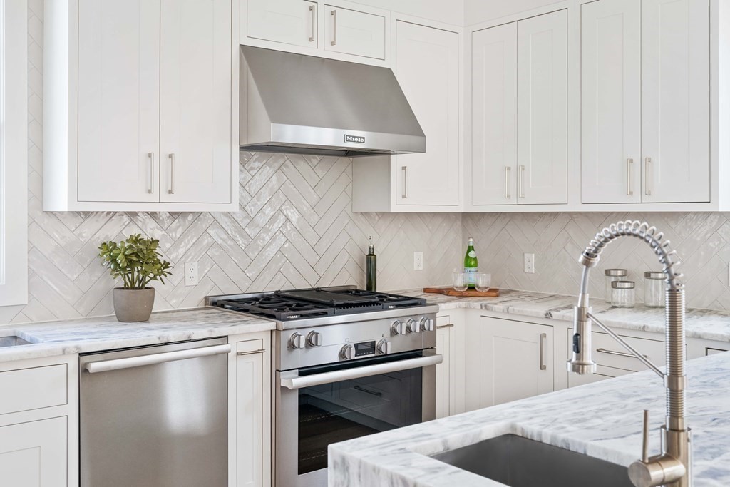 33 Summit Avenue, Unit 33 Brookline, MA 02446 - Photo 4 of 28 a kitchen with stainless steel appliances granite countertop a stove a sink and white cabinets