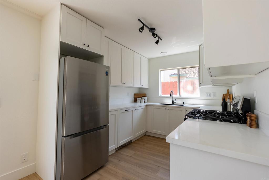841 Friendly Circle El Cajon, CA 92021 - Photo 13 of 20 a kitchen with a refrigerator a stove a sink and cabinets