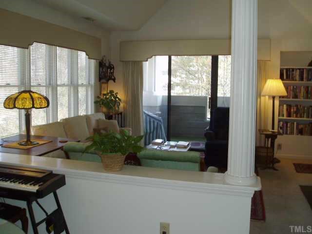 Bright living room open from dining room with walk out porch, vaulted ceiling and fireplace.