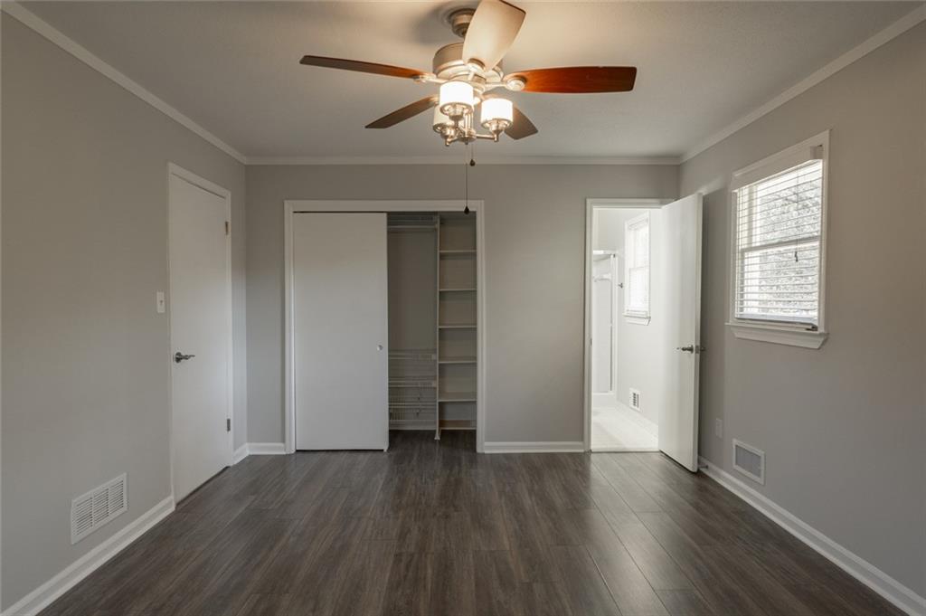 3599 Lower Roswell Road Marietta, GA 30068 - Photo 29 of 64 an empty room with wooden floor chandelier fan and windows