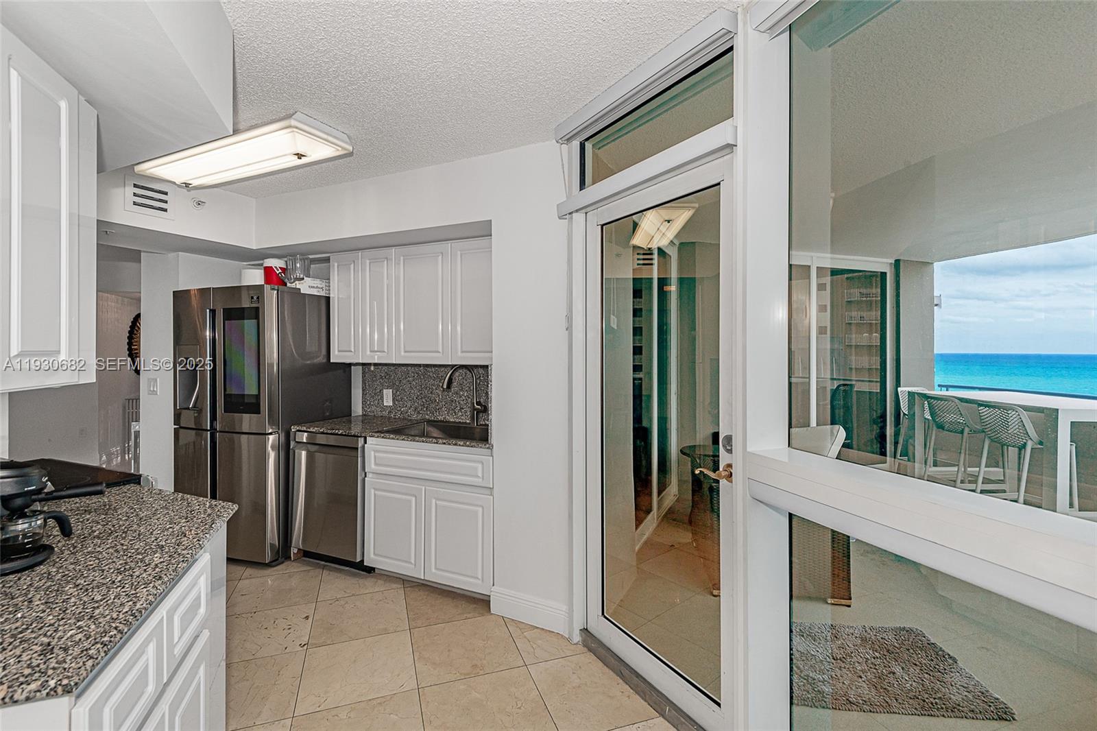 6301 Collins Avenue, Unit 1605 Miami Beach, FL 33141 - Photo 16 of 23 a kitchen with a stove a refrigerator and a sink