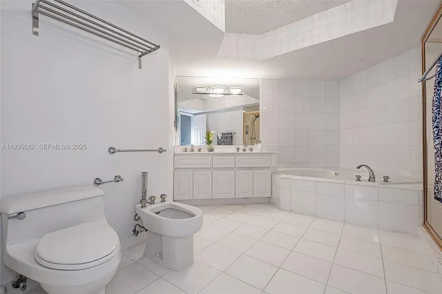 a bathroom with a toilet a sink a mirror and a bathtub