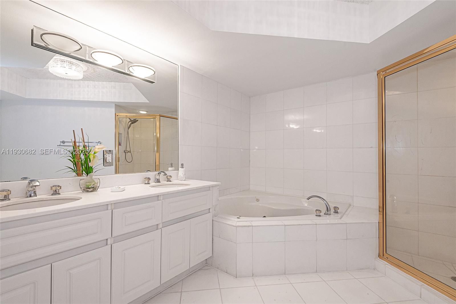 6301 Collins Avenue, Unit 1605 Miami Beach, FL 33141 - Photo 21 of 23 a bathroom with a bathtub a mirror a sink and vanity