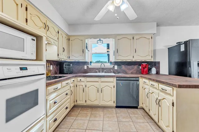a kitchen with granite countertop a sink stainless steel appliances and cabinets