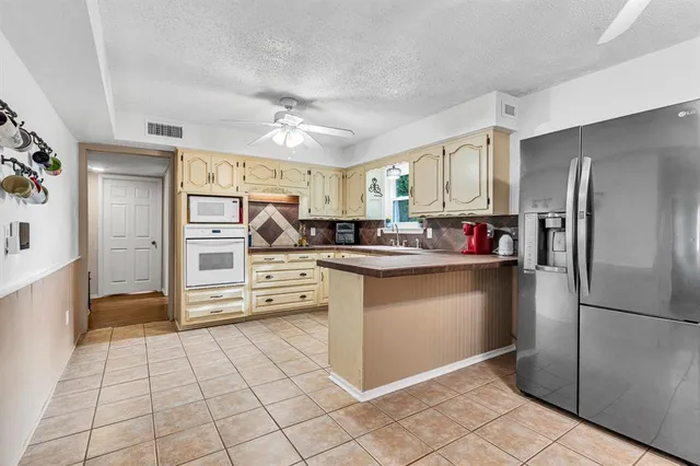 a kitchen with stainless steel appliances granite countertop a refrigerator and a stove top oven