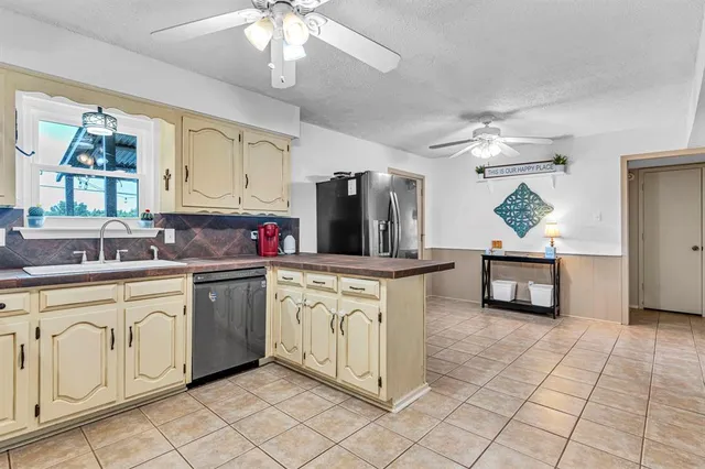 a kitchen with stainless steel appliances granite countertop a sink and a refrigerator