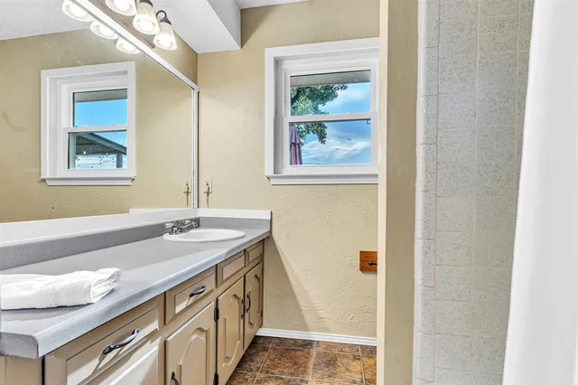 a bathroom with a granite countertop sink and a mirror