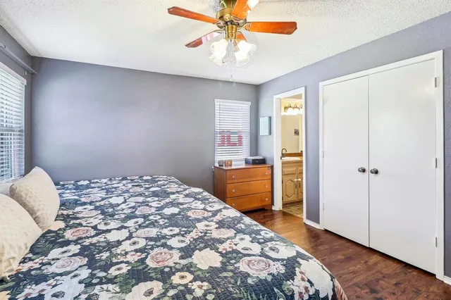 a bedroom with a large bed and a chandelier fan