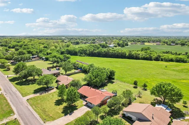 an aerial view of residential houses with outdoor space and trees
