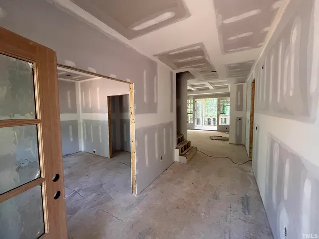a view of a hallway with furniture and a window