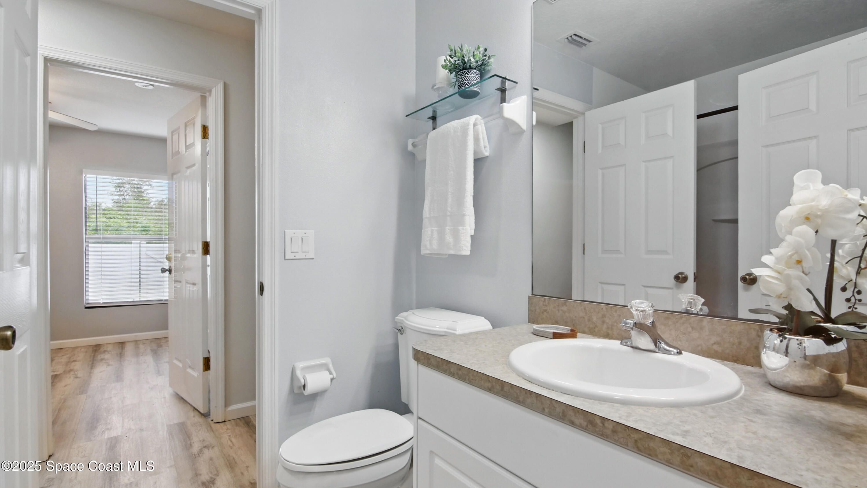 1160 Luminary Circle, Unit 105 Melbourne, FL 32901 - Photo 12 of 16 a bathroom with a toilet a sink and a mirror