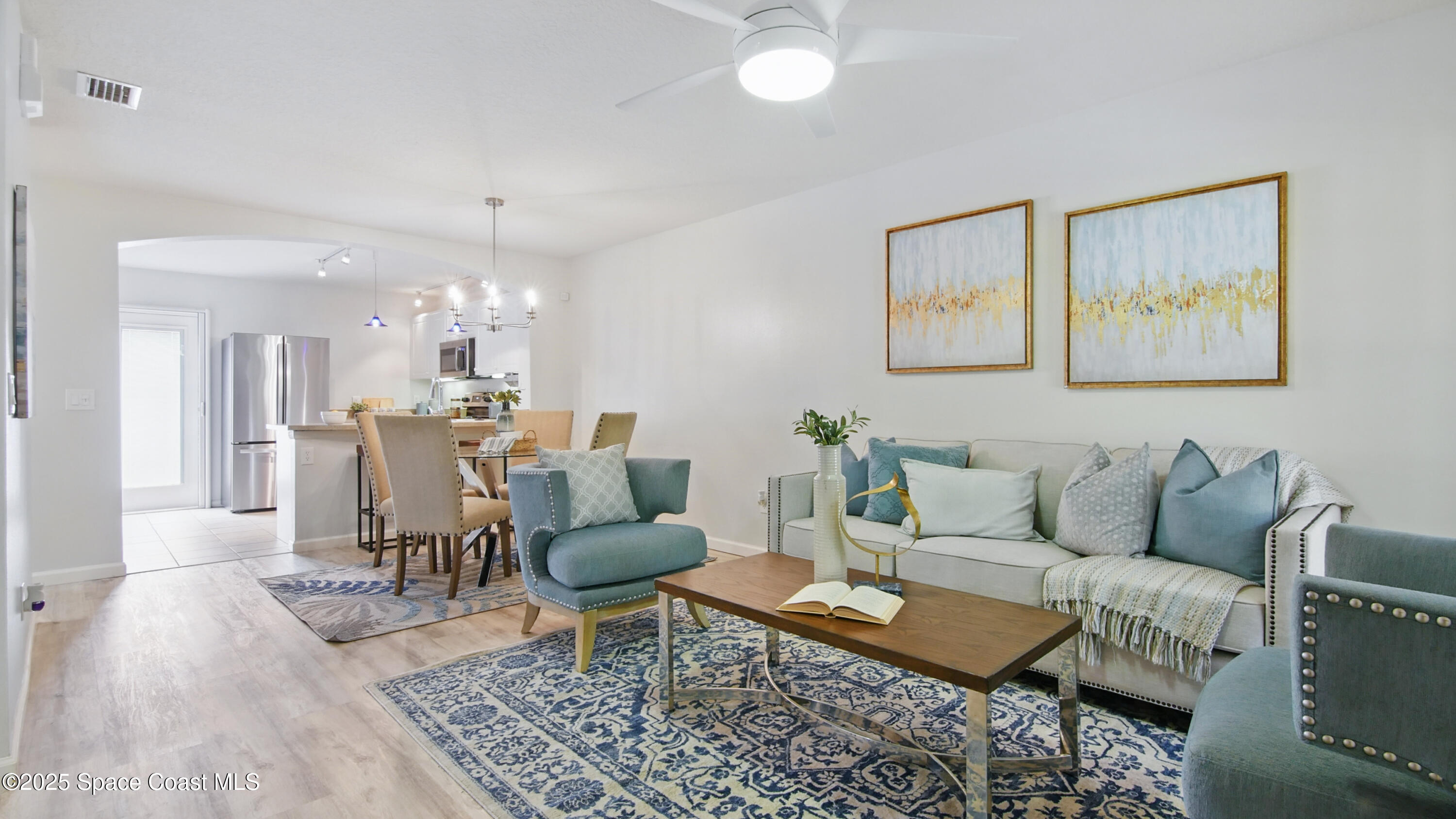 1160 Luminary Circle, Unit 105 Melbourne, FL 32901 - Photo 5 of 16 a living room with furniture and a dining table with wooden floor
