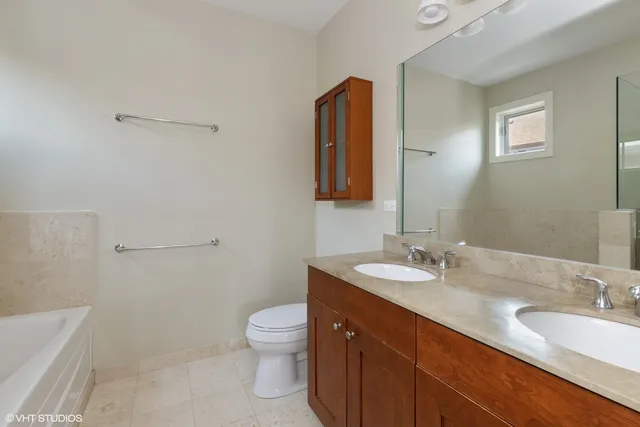 a bathroom with a granite countertop sink a toilet and a bathtub