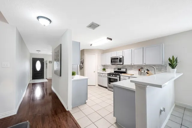 a kitchen with sink a microwave and cabinets