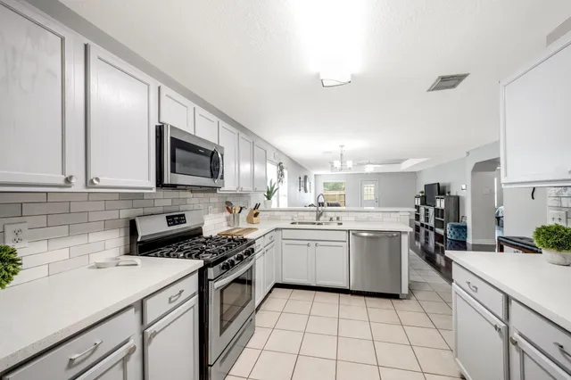 a kitchen with a sink a stove top oven and cabinets