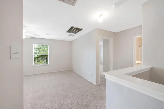 a view of room with window and a ceiling fan
