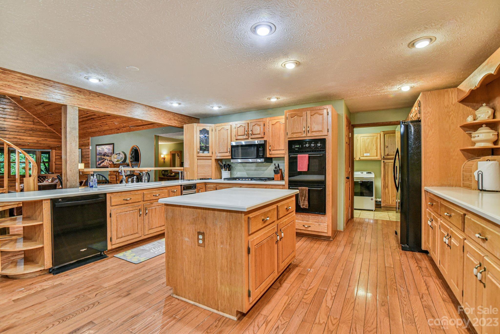 32 Magic Mountain Road Candler, NC 28715 - Photo 12 of 44 a kitchen with stainless steel appliances granite countertop wooden cabinets and wooden floors