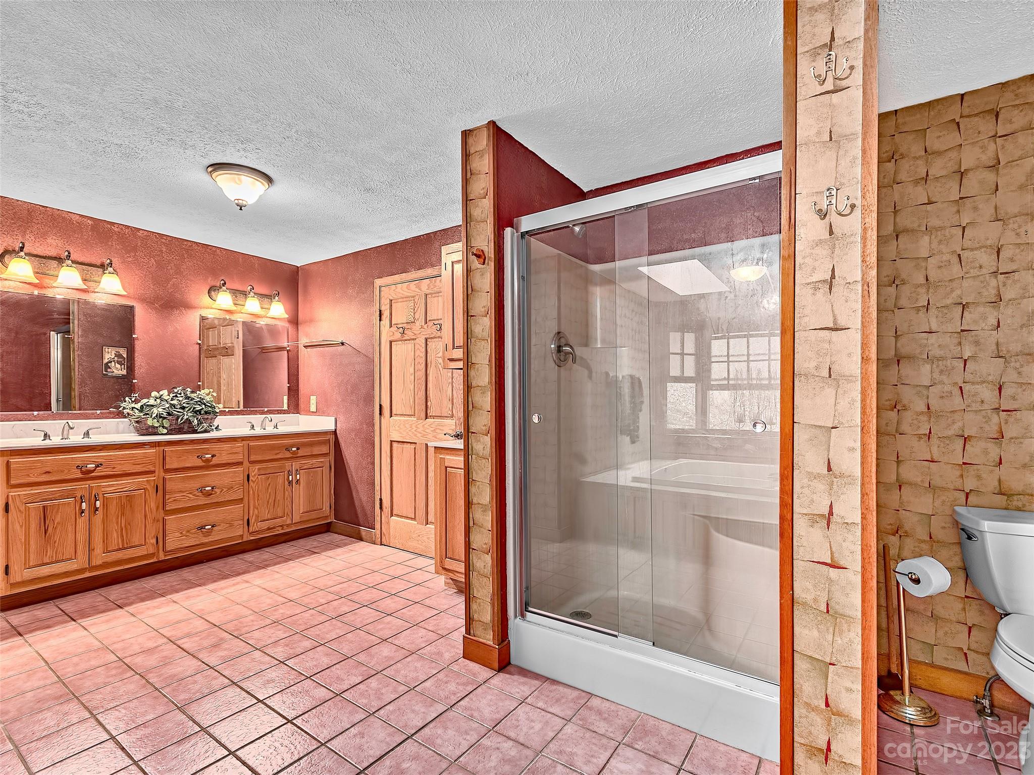 32 Magic Mountain Road Candler, NC 28715 - Photo 21 of 44 a large bathroom with a glass door shower a sink and a mirror
