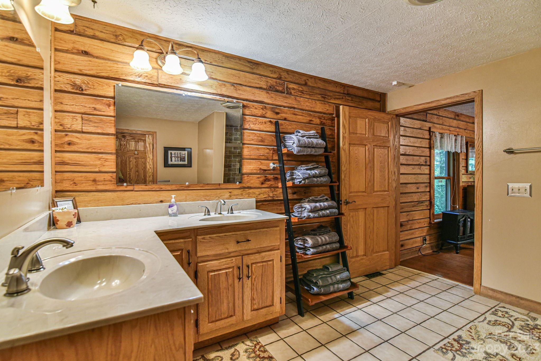 32 Magic Mountain Road Candler, NC 28715 - Photo 26 of 44 a bathroom with a sink a mirror and a shower