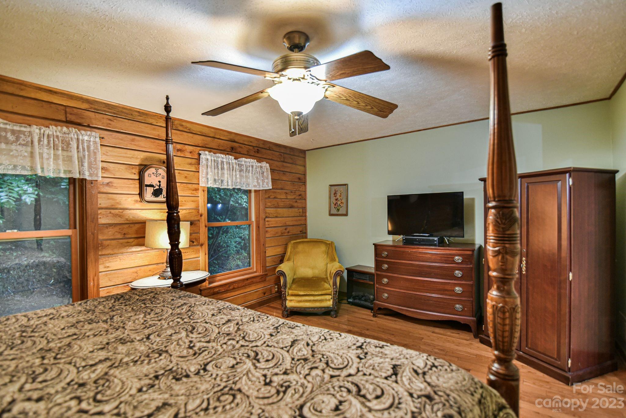 32 Magic Mountain Road Candler, NC 28715 - Photo 30 of 44 a bedroom with furniture and a flat screen tv