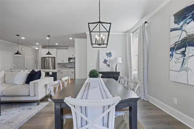 a view of a dining room and livingroom with furniture wooden floor a chandelier