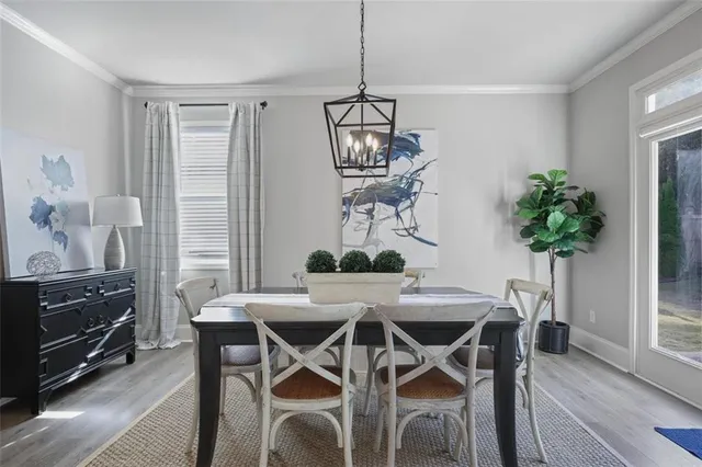 a view of a dining room with furniture a chandelier and wooden floor