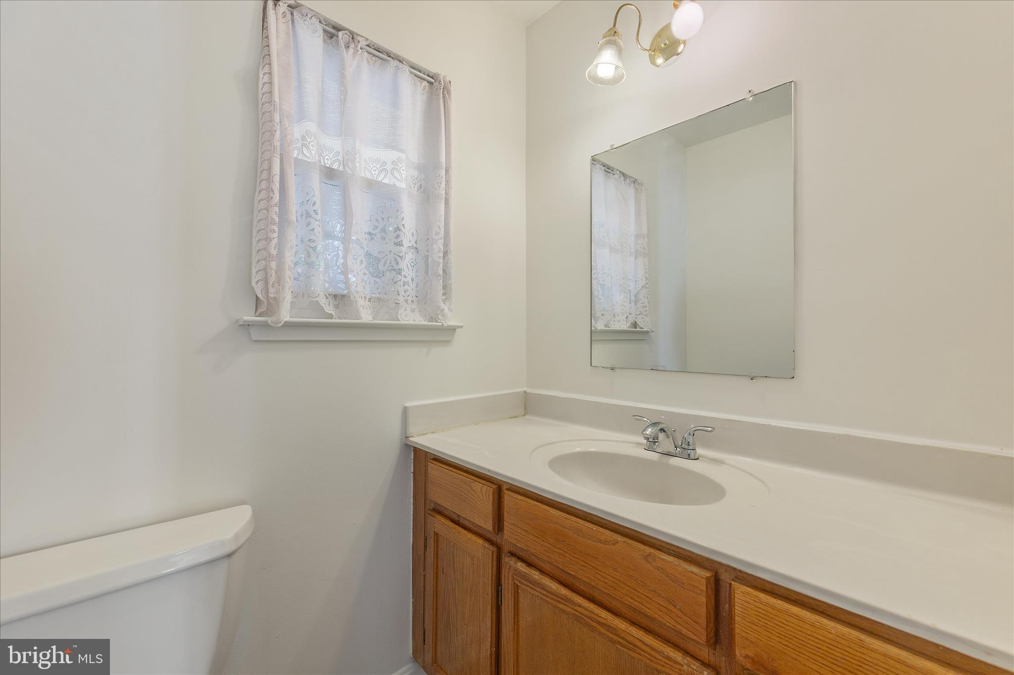 8710 Post Oak Way Landover, MD 20785 - Photo 14 of 38 a bathroom with a sink toilet and mirror