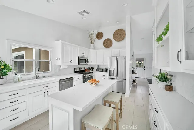 a large kitchen with a lot of counter space and wooden floor