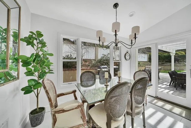 a dining room with furniture potted plants and wooden floor
