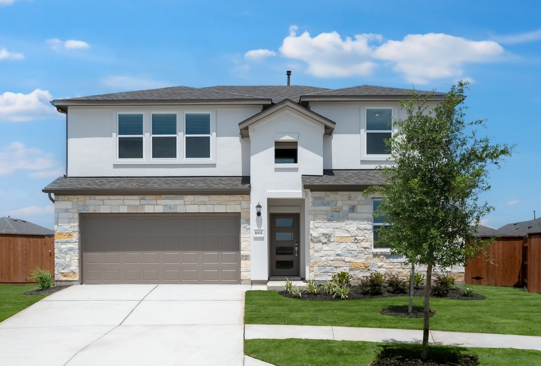 a front view of a house with a yard and garage