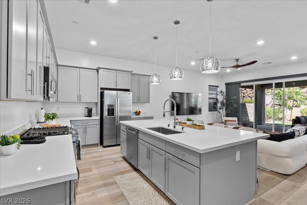 20 Charlotte Ridge Place Henderson, NV 89011 - Photo 14 of 33 A contemporary kitchen boasts a spacious island with an undermount sink and sleek stainless steel appliances.
