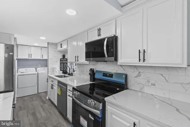 a kitchen with stainless steel appliances a sink stove and microwave