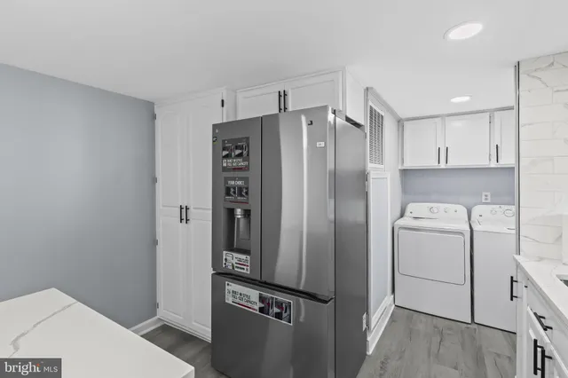 a view of a refrigerator in kitchen and an empty room