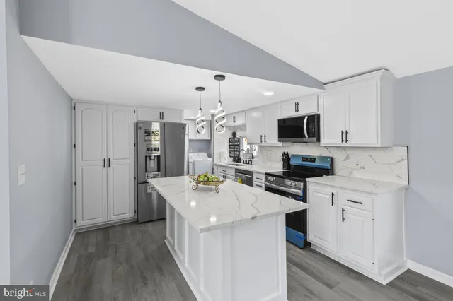 a kitchen with a sink a counter top space stainless steel appliances and cabinets